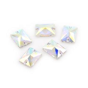 May include: Five iridescent clear rectangular rhinestones with a star-shaped pattern inside.