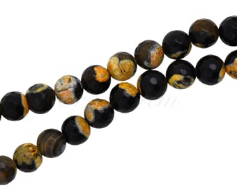 May include: A strand of black and orange agate beads. The beads are faceted and have a natural, irregular shape.
