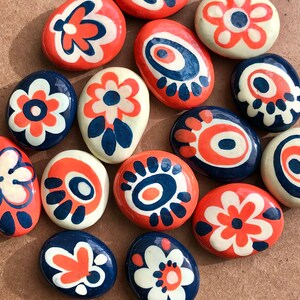 Fun, colorful, very small painted rocks · Navy, orange and cream colors · Sets of 7 kindness stones