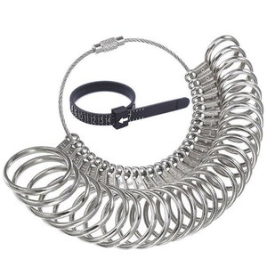 May include: A silver ring sizer with a black measuring tape. The sizer has 20 rings, each with a number from 0 to 19. The rings are connected by a silver chain.