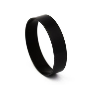 Op de afbeelding: Een zwarte rubberen ring, waarschijnlijk gebruikt voor een mechanisch of industrieel doel.