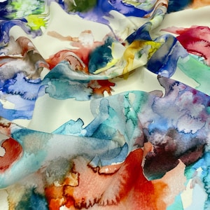 May include: Abstract watercolor print fabric in shades of blue, green, yellow, orange, and red on a white background.