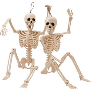 May include: Two off-white plastic skeleton figures in a seated position. Each skeleton features a movable jaw, articulated joints at the shoulders, elbows, hips, and knees, and a black hanging loop attached to the top of the skull for display purposes.