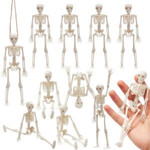 May include: A collection of ten off-white plastic skeleton figurines in various poses, including standing, sitting, and hanging from a brown string. Each articulated skeleton features a detailed rib cage, skull, and limbs, presented against a white background.