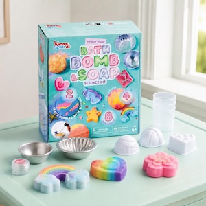 May include: A Klever Kits Make Your Bath Bomb & Soap Science Kit box featuring colorful graphics of bath bombs and molds. Included are two metal bowls, a small container of glitter, four white plastic molds, and several finished bath bombs.