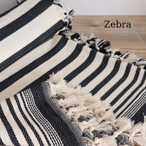 May include: Black and white striped throw blanket with fringe tassels. The blanket has a "Zebra" label.