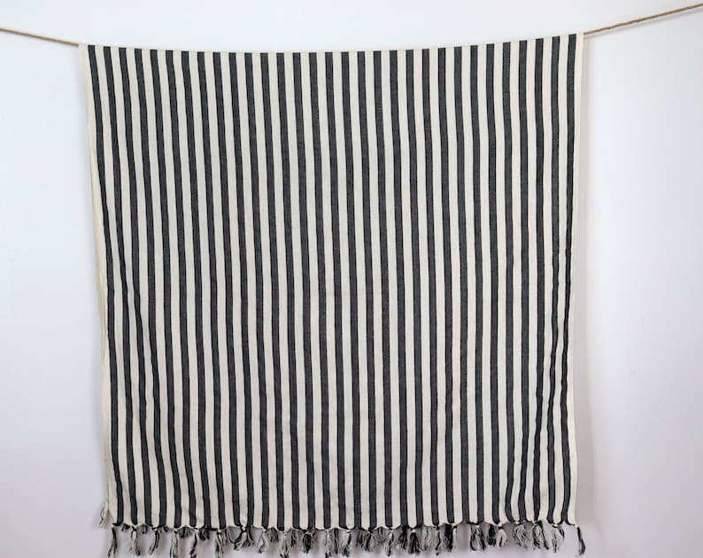 May include: Black and white striped throw blanket with fringe trim.