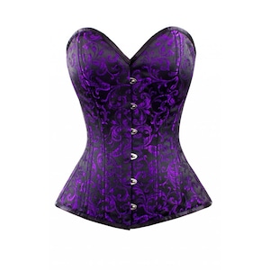 Puede incluir: Corsé negro y morado con un diseño floral. El corsé tiene un escote corazón y se abrocha con broches plateados. La estructura de ballenas es visible. La prenda está diseñada para ceñir la cintura y crear una figura de reloj de arena.
