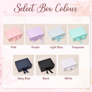 May include: An image displays eight gift boxes in various colors: pink, purple, light blue, turquoise, navy blue, black, and white. Each box is closed with a matching ribbon. The text "Select Box Colour" is at the top.