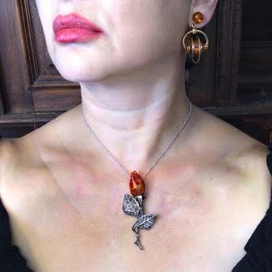 This vintage STERLiNG AMBER ROSE PiN is stunning!  A cognac colored piece of amber has been carved into a rosebud and set in a sterling silver. It's accented with a THORNY stem and two VERY realistic leaves.  PLEASE  check out the leaves.  They're amazing!   It's of course a pin but I kinda like it as a pendant.