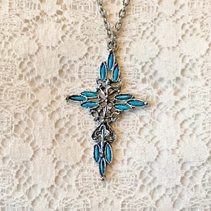 This vintage ZUNI styLe Petit PoiNT CroSS NECKLACE is a great pretender!  Turquoise plastic cabochons mimic the petit point jewelry the Zuni Indians are famous for.  They're set in a silver tone metal.  It's a pretty little western cross that comes on a really nice silver rolo chain.  The links have a  nice stamped line pattern.  You'll receive the pendant and 24" chain.