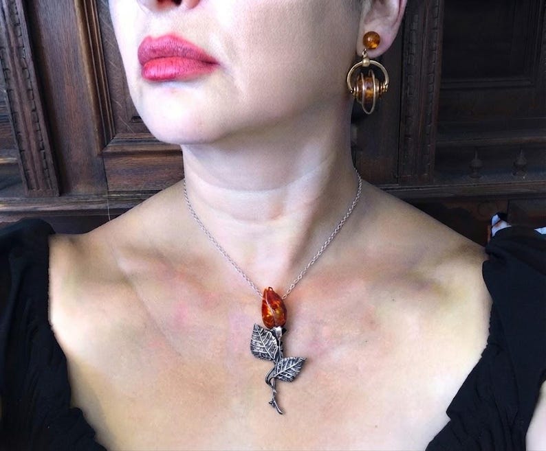 This vintage STERLiNG AMBER ROSE PiN is stunning!  A cognac colored piece of amber has been carved into a rosebud and set in a sterling silver. It's accented with a THORNY stem and two VERY realistic leaves.  PLEASE  check out the leaves.  They're amazing!   It's of course a pin but I kinda like it as a pendant.