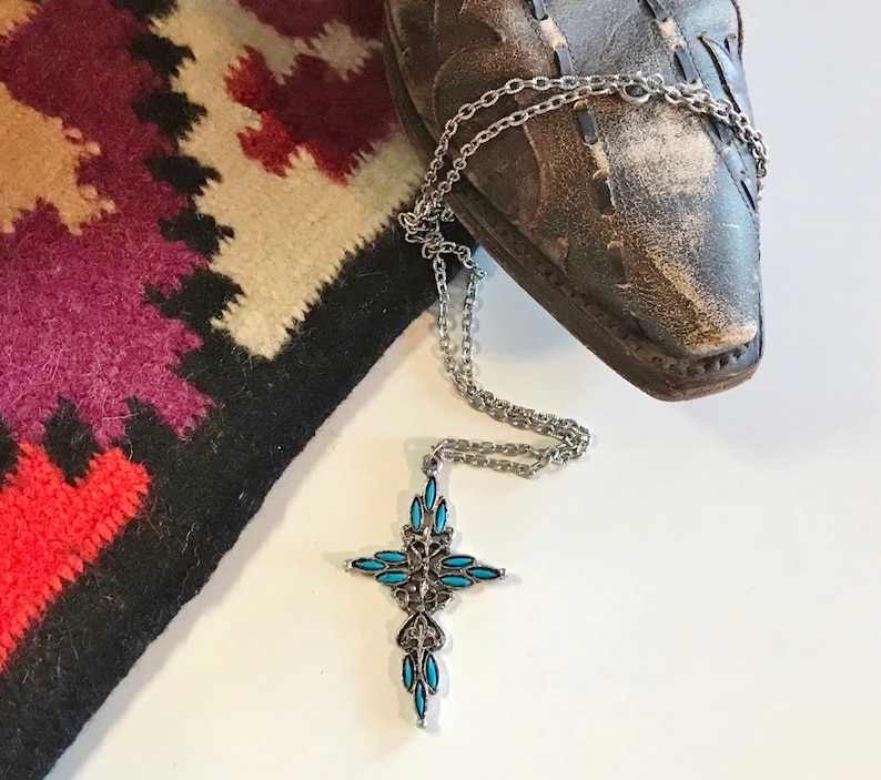 This vintage ZUNI styLe Petit PoiNT CroSS NECKLACE is a great pretender!  Turquoise plastic cabochons mimic the petit point jewelry the Zuni Indians are famous for.  They're set in a silver tone metal.  It's a pretty little western cross that comes on a really nice silver rolo chain.  The links have a  nice stamped line pattern.  You'll receive the pendant and 24" chain.