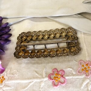 This vintage ViCTORIAN StERLiNG SASH BUCKLE is an amazing!  It's a whopping 3-1/4" long and has Delicate lacy filigree edges and faceted circles of silver that twinkle and shine.  There are 3 sharp prongs that swivel back and forth on a hinge.  There is also a second piece of metal on the back with 4 prongs that also swivels...perhaps to hold the material secure.  It's in great condition and would look glorious on a wedding belt.  Original Patina or very tarnished.