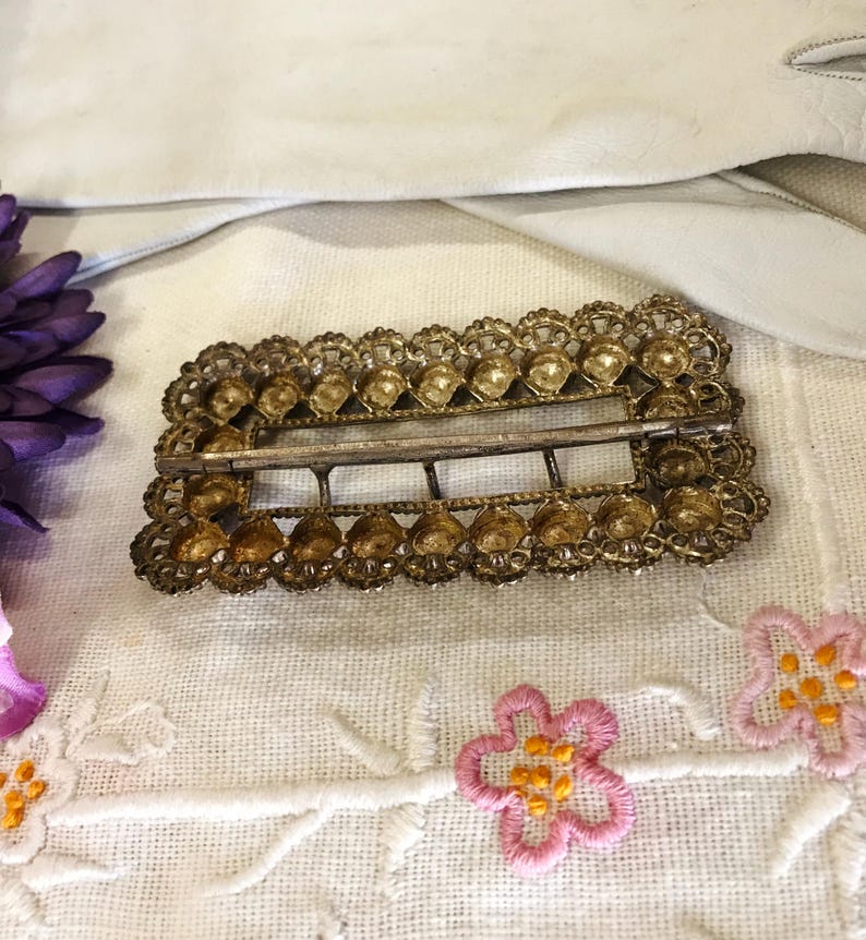 This vintage ViCTORIAN StERLiNG SASH BUCKLE is an amazing!  It's a whopping 3-1/4" long and has Delicate lacy filigree edges and faceted circles of silver that twinkle and shine.  There are 3 sharp prongs that swivel back and forth on a hinge.  There is also a second piece of metal on the back with 4 prongs that also swivels...perhaps to hold the material secure.  It's in great condition and would look glorious on a wedding belt.  Original Patina or very tarnished.
