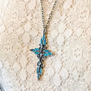 This vintage ZUNI styLe Petit PoiNT CroSS NECKLACE is a great pretender!  Turquoise plastic cabochons mimic the petit point jewelry the Zuni Indians are famous for.  They're set in a silver tone metal.  It's a pretty little western cross that comes on a really nice silver rolo chain.  The links have a  nice stamped line pattern.  You'll receive the pendant and 24" chain.