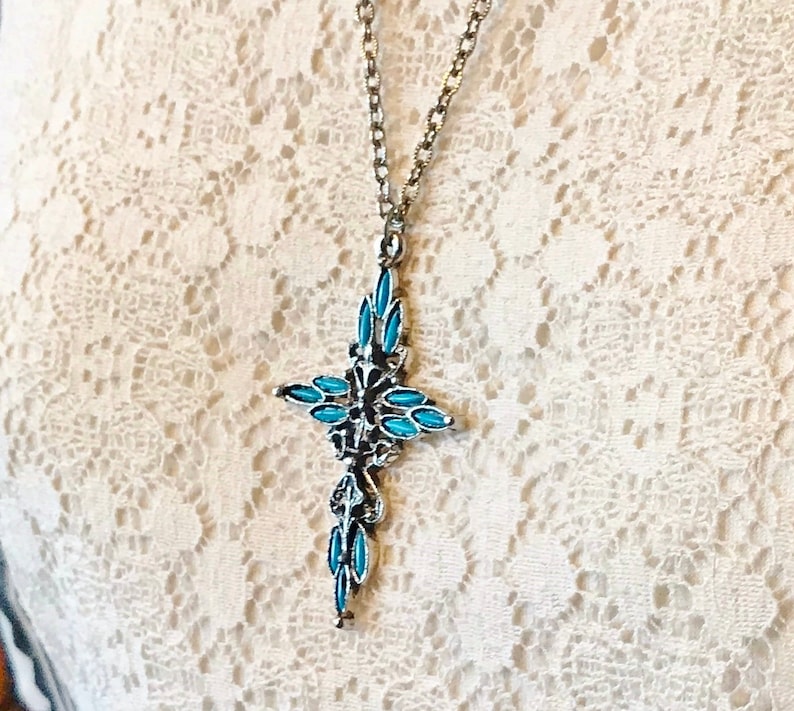 This vintage ZUNI styLe Petit PoiNT CroSS NECKLACE is a great pretender!  Turquoise plastic cabochons mimic the petit point jewelry the Zuni Indians are famous for.  They're set in a silver tone metal.  It's a pretty little western cross that comes on a really nice silver rolo chain.  The links have a  nice stamped line pattern.  You'll receive the pendant and 24" chain.