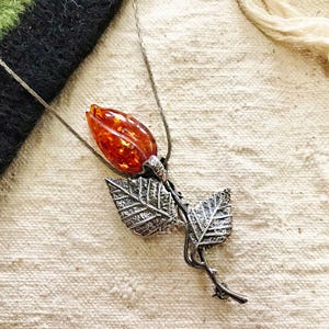This vintage STERLiNG AMBER ROSE PiN is stunning!  A cognac colored piece of amber has been carved into a rosebud and set in a sterling silver. It's accented with a THORNY stem and two VERY realistic leaves.  PLEASE  check out the leaves.  They're amazing!   It's of course a pin but I kinda like it as a pendant.