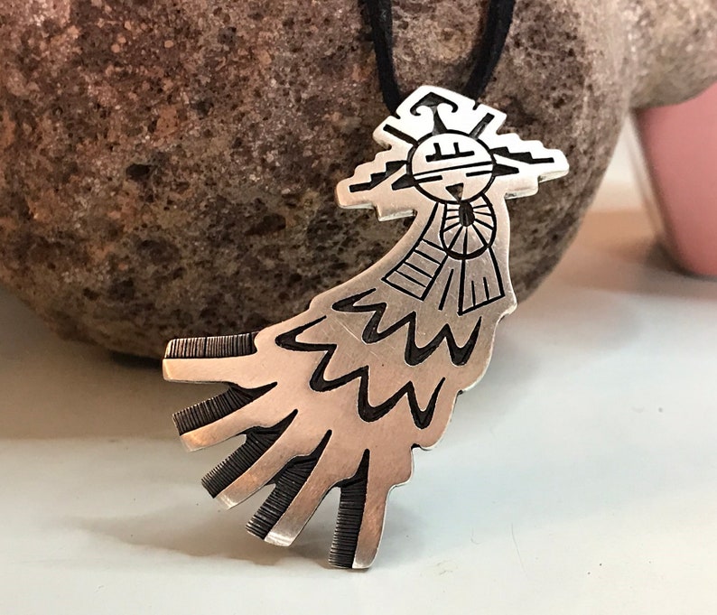 This vintage HOPI STERLiNg OVERLAY KaCHiNa PENDANT is BEAUTIFULLY MADE!  Nice deep cuts and a stylized modern design make this a very unique pendant.  It's unsigned but  the unusual tiny feathery design on the bottom that looks like tiny combs, can be seen in the work of Sparks Masawytewa.  It's in great condition and has a generous bale on the back.   It's 2-1/8"  and would make a lovely gift for someone who loves Native American Jewelry.