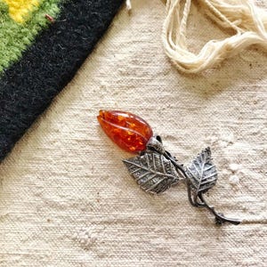 This vintage STERLiNG AMBER ROSE PiN is stunning!  A cognac colored piece of amber has been carved into a rosebud and set in a sterling silver. It's accented with a THORNY stem and two VERY realistic leaves.  PLEASE  check out the leaves.  They're amazing!   It's of course a pin but I kinda like it as a pendant.