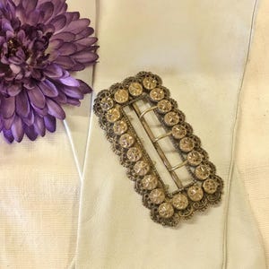 This vintage ViCTORIAN StERLiNG SASH BUCKLE is an amazing!  It's a whopping 3-1/4" long and has Delicate lacy filigree edges and faceted circles of silver that twinkle and shine.  There are 3 sharp prongs that swivel back and forth on a hinge.  There is also a second piece of metal on the back with 4 prongs that also swivels...perhaps to hold the material secure.  It's in great condition and would look glorious on a wedding belt.  Original Patina or very tarnished.