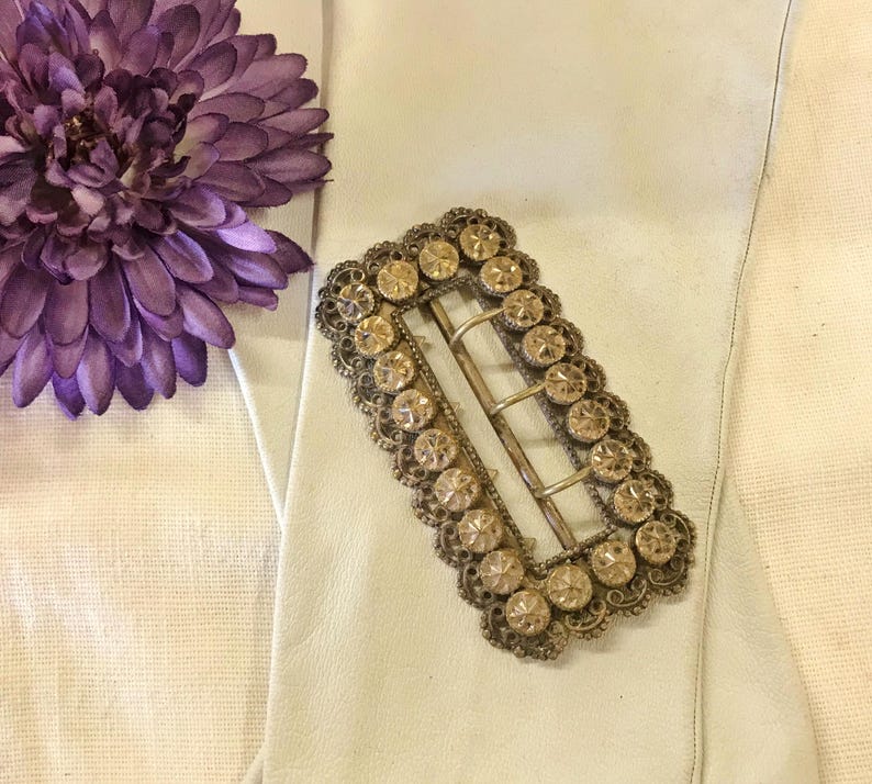 This vintage ViCTORIAN StERLiNG SASH BUCKLE is an amazing!  It's a whopping 3-1/4" long and has Delicate lacy filigree edges and faceted circles of silver that twinkle and shine.  There are 3 sharp prongs that swivel back and forth on a hinge.  There is also a second piece of metal on the back with 4 prongs that also swivels...perhaps to hold the material secure.  It's in great condition and would look glorious on a wedding belt.  Original Patina or very tarnished.
