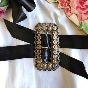 This vintage ViCTORIAN StERLiNG SASH BUCKLE is an amazing!  It's a whopping 3-1/4" long and has Delicate lacy filigree edges and faceted circles of silver that twinkle and shine.  There are 3 sharp prongs that swivel back and forth on a hinge.  There is also a second piece of metal on the back with 4 prongs that also swivels...perhaps to hold the material secure.  It's in great condition and would look glorious on a wedding belt.  Original Patina or very tarnished.