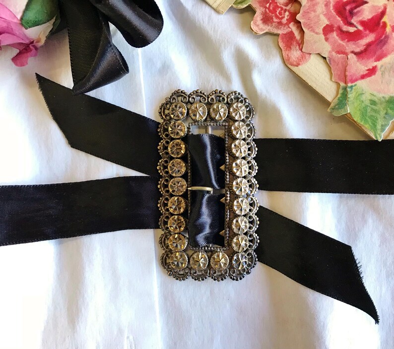 This vintage ViCTORIAN StERLiNG SASH BUCKLE is an amazing!  It's a whopping 3-1/4" long and has Delicate lacy filigree edges and faceted circles of silver that twinkle and shine.  There are 3 sharp prongs that swivel back and forth on a hinge.  There is also a second piece of metal on the back with 4 prongs that also swivels...perhaps to hold the material secure.  It's in great condition and would look glorious on a wedding belt.  Original Patina or very tarnished.