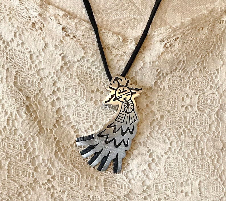 This vintage HOPI STERLiNg OVERLAY KaCHiNa PENDANT is BEAUTIFULLY MADE!  Nice deep cuts and a stylized modern design make this a very unique pendant.  It's unsigned but  the unusual tiny feathery design on the bottom that looks like tiny combs, can be seen in the work of Sparks Masawytewa.  It's in great condition and has a generous bale on the back.   It's 2-1/8"  and would make a lovely gift for someone who loves Native American Jewelry.