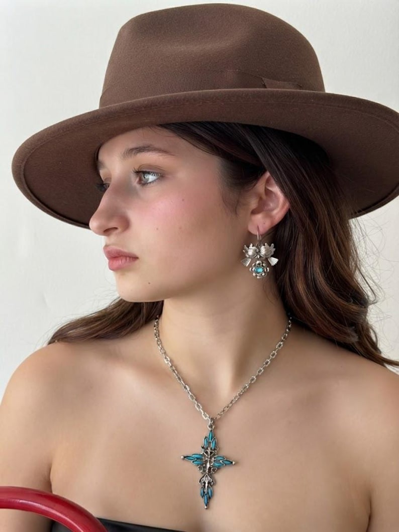This vintage ZUNI styLe Petit PoiNT CroSS NECKLACE is a great pretender!  Turquoise plastic cabochons mimic the petit point jewelry the Zuni Indians are famous for.  They're set in a silver tone metal.  It's a pretty little western cross that comes on a really nice silver rolo chain.  The links have a  nice stamped line pattern.  You'll receive the pendant and 24" chain.