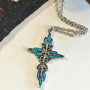 This vintage ZUNI styLe Petit PoiNT CroSS NECKLACE is a great pretender!  Turquoise plastic cabochons mimic the petit point jewelry the Zuni Indians are famous for.  They're set in a silver tone metal.  It's a pretty little western cross that comes on a really nice silver rolo chain.  The links have a  nice stamped line pattern.  You'll receive the pendant and 24" chain.