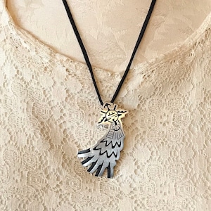 This vintage HOPI STERLiNg OVERLAY KaCHiNa PENDANT is BEAUTIFULLY MADE!  Nice deep cuts and a stylized modern design make this a very unique pendant.  It's unsigned but  the unusual tiny feathery design on the bottom that looks like tiny combs, can be seen in the work of Sparks Masawytewa.  It's in great condition and has a generous bale on the back.   It's 2-1/8"  and would make a lovely gift for someone who loves Native American Jewelry.