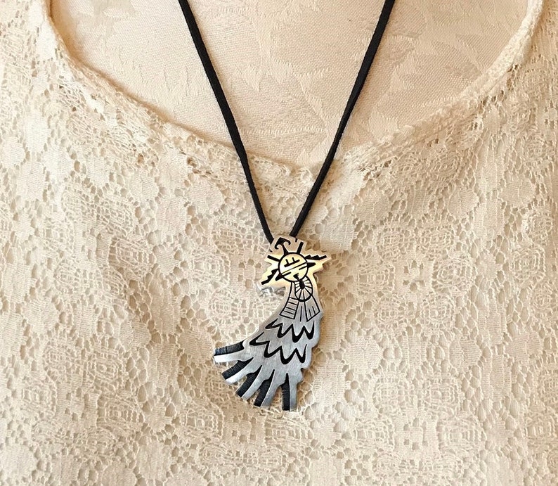 This vintage HOPI STERLiNg OVERLAY KaCHiNa PENDANT is BEAUTIFULLY MADE!  Nice deep cuts and a stylized modern design make this a very unique pendant.  It's unsigned but  the unusual tiny feathery design on the bottom that looks like tiny combs, can be seen in the work of Sparks Masawytewa.  It's in great condition and has a generous bale on the back.   It's 2-1/8"  and would make a lovely gift for someone who loves Native American Jewelry.