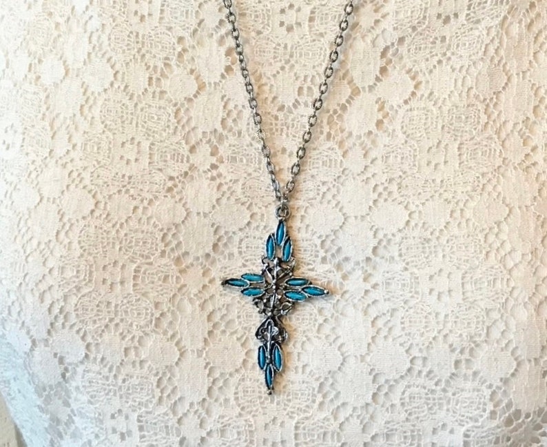 This vintage ZUNI styLe Petit PoiNT CroSS NECKLACE is a great pretender!  Turquoise plastic cabochons mimic the petit point jewelry the Zuni Indians are famous for.  They're set in a silver tone metal.  It's a pretty little western cross that comes on a really nice silver rolo chain.  The links have a  nice stamped line pattern.  You'll receive the pendant and 24" chain.
