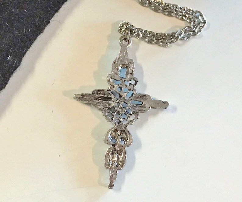 This vintage ZUNI styLe Petit PoiNT CroSS NECKLACE is a great pretender!  Turquoise plastic cabochons mimic the petit point jewelry the Zuni Indians are famous for.  They're set in a silver tone metal.  It's a pretty little western cross that comes on a really nice silver rolo chain.  The links have a  nice stamped line pattern.  You'll receive the pendant and 24" chain.