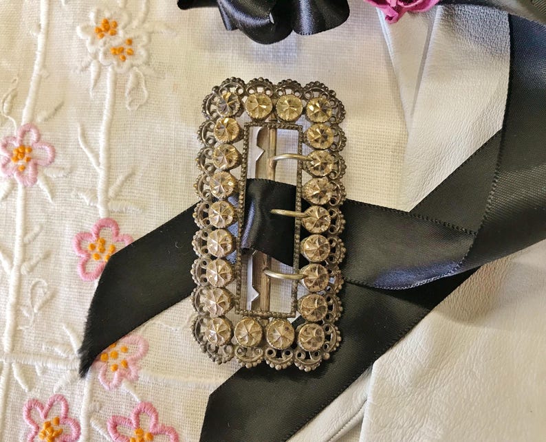 This vintage ViCTORIAN StERLiNG SASH BUCKLE is an amazing!  It's a whopping 3-1/4" long and has Delicate lacy filigree edges and faceted circles of silver that twinkle and shine.  There are 3 sharp prongs that swivel back and forth on a hinge.  There is also a second piece of metal on the back with 4 prongs that also swivels...perhaps to hold the material secure.  It's in great condition and would look glorious on a wedding belt.  Original Patina or very tarnished.