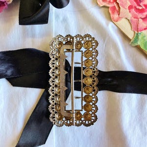 This vintage ViCTORIAN StERLiNG SASH BUCKLE is an amazing!  It's a whopping 3-1/4" long and has Delicate lacy filigree edges and faceted circles of silver that twinkle and shine.  There are 3 sharp prongs that swivel back and forth on a hinge.  There is also a second piece of metal on the back with 4 prongs that also swivels...perhaps to hold the material secure.  It's in great condition and would look glorious on a wedding belt.  Original Patina or very tarnished.
