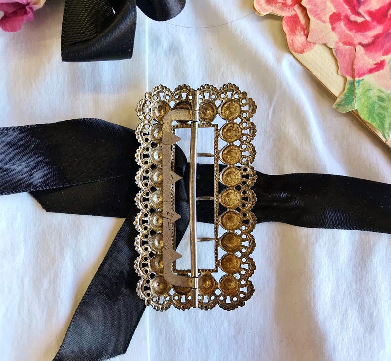 This vintage ViCTORIAN StERLiNG SASH BUCKLE is an amazing!  It's a whopping 3-1/4" long and has Delicate lacy filigree edges and faceted circles of silver that twinkle and shine.  There are 3 sharp prongs that swivel back and forth on a hinge.  There is also a second piece of metal on the back with 4 prongs that also swivels...perhaps to hold the material secure.  It's in great condition and would look glorious on a wedding belt.  Original Patina or very tarnished.