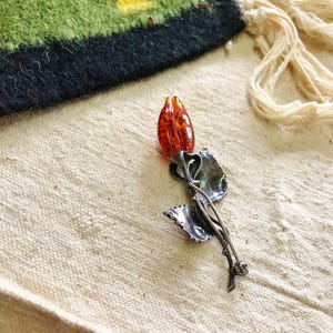 This vintage STERLiNG AMBER ROSE PiN is stunning!  A cognac colored piece of amber has been carved into a rosebud and set in a sterling silver. It's accented with a THORNY stem and two VERY realistic leaves.  PLEASE  check out the leaves.  They're amazing!   It's of course a pin but I kinda like it as a pendant.