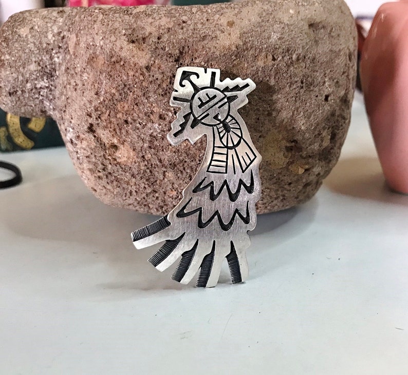This vintage HOPI STERLiNg OVERLAY KaCHiNa PENDANT is BEAUTIFULLY MADE!  Nice deep cuts and a stylized modern design make this a very unique pendant.  It's unsigned but  the unusual tiny feathery design on the bottom that looks like tiny combs, can be seen in the work of Sparks Masawytewa.  It's in great condition and has a generous bale on the back.   It's 2-1/8"  and would make a lovely gift for someone who loves Native American Jewelry.