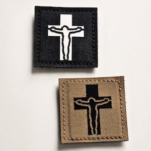 Könnte beinhalten: Zwei quadratische Aufnäher mit einem Kreuzdesign. Einer ist schwarz mit einem weißen Kreuz und einer Jesusfigur. Der andere ist beige mit einem schwarzen Kreuz und einer Jesusfigur.