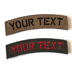 Könnte beinhalten: Zwei gebogene Stoffaufnäher. Der obere Aufnäher ist beige mit schwarzem Text "YOUR TEXT". Der untere Aufnäher ist olivgrün mit rotem Text "YOUR TEXT". Beide Aufnäher haben einen genähten Rand.