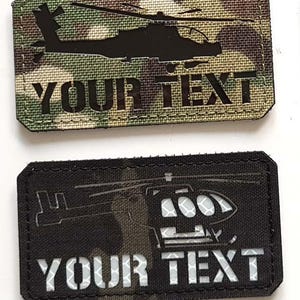 Op de afbeelding: Een verzameling rechthoekige patches met helikopterontwerpen en de tekst "YOUR TEXT". Sommige patches hebben een camouflage-achtergrond, andere zijn zwart. Eén patch heeft een "LASER PATCH"-logo en een leeuwenembleem.