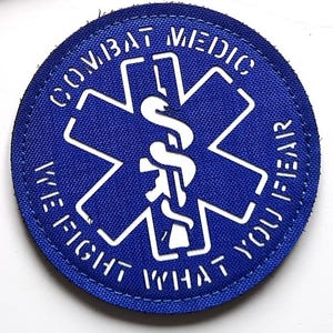 May include: Two embroidered patches. One black rectangular patch with three coloured lion figures and the text "LASER PATCH" in white. The other is a blue circular patch with a white medical symbol and the text "COMBAT MEDIC WE FIGHT WHAT YOU FEAR".