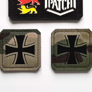 May include: A collection of tactical patches. One black patch features three colored lion emblems and the text "LASER PATCH" in white. Two square patches with a camouflage pattern and a black cross design are also shown.