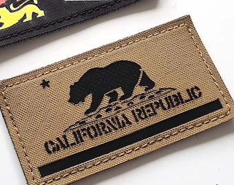 May include: Two rectangular patches. One black patch features the text "LASER PATCH" in white and three stylized lion figures. The other patch is tan with a black bear silhouette and the words "CALIFORNIA REPUBLIC".