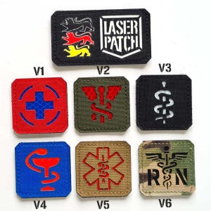 Può includere: Una collezione di toppe tattiche con vari disegni a tema medico e militare. Include una toppa con la scritta "LASER PATCH" e un simbolo a croce. Altre toppe presentano simboli medici e le lettere "RN".