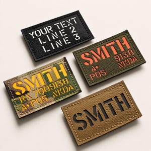 Op de afbeelding: Vier rechthoekige patches met geborduurde randen. Eén zwarte patch leest "YOUR TEXT LINE 2 LINE 3" in het wit. Andere patches tonen de naam "SMITH" met extra tekst en cijfers in oranje, geel en zwart.