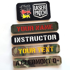 May include: Five black and white embroidered patches with different text. The top patch says "Laser Patch" with a white shield design. The second patch says "Your Name" in red text. The third patch says "Instructor" in white text. The fourth patch says "Your Text" in yellow text. The fifth patch says "A. Clermont O+" in black text.