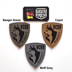 May include: A selection of embroidered patches in different colours. The patches feature a black and white rectangular patch with the text "LASER PATCH" and a shield-shaped patch with a dog graphic and the text "K9 WHISKY". Colours include Ranger Green, Coyote, and Wolf Grey.